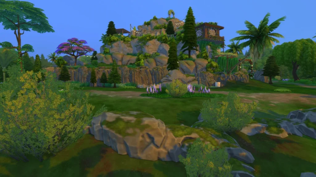 A fully explorable mountain build in The Sims 4 featuring layered rock formations, walkable paths, lush greenery, and decorative structures integrated into the mountainside.