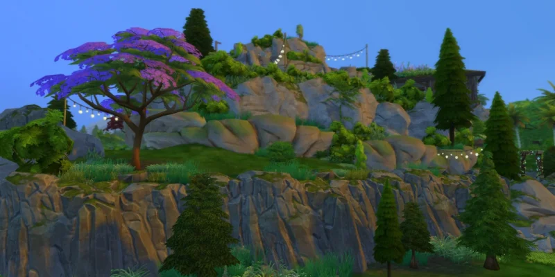 An upper cliff view of a fully explorable mountain build in The Sims 4 with layered rock formations, lush greenery, string lights, trees, and walkable paths leading toward the summit.