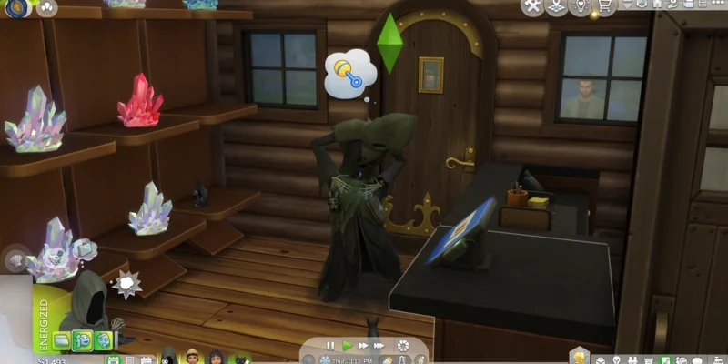 Screenshot from The Sims 4 showing the Grim Reaper in a log cabin, holding his stomach with a pacifier thought bubble above his head. Crystal displays sit on shelves beside a computer desk.