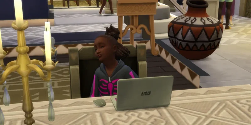 A Sims 4 child Sim sitting at a desk with a laptop, smiling proudly, with candles and home decor visible around them.